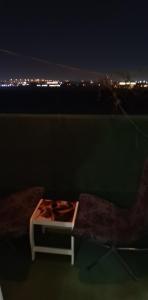 łóżko siedzące na balkonie w nocy w obiekcie شقة السلمة أم القيوين w mieście Umm al-Kuwajn