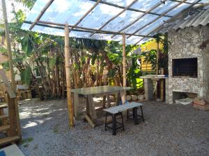 a picnic table and a bench under a pergola at Residencial Álacre casa e cabana aluguel Ferrugem SC in Garopaba +10 photos