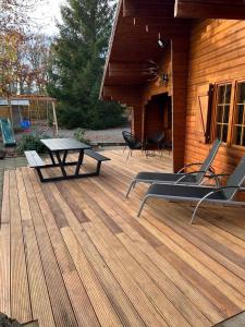 a wooden deck with a picnic table and chairs at Chalet Du Val 53 in Vesin