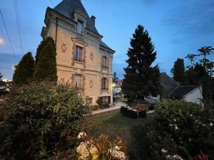 an old building with a tree in the yard at Gite L'Instant Champenois in Bréviandes