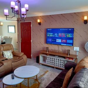 a living room with couches and a flat screen tv at BELLS TRIAD - FREE TRANSPORT FROM AIRPORT FOR PRE PAYMENT BOOKINGs in Nairobi