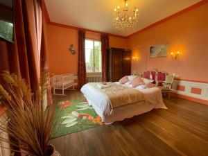 a bedroom with a bed and a chandelier at Gite L'Instant Champenois in Bréviandes