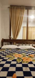 a bedroom with a bed with a checkered floor at Whispering Pinewoods in Pīrmed