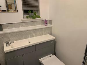 a bathroom with a sink and a toilet at Modern 2 bed apartment in Wallasey