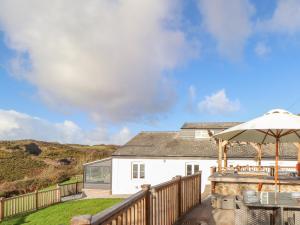 a house with a deck with an umbrella at Wild Acres in Helston