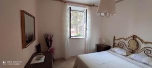 a bedroom with a bed with a mirror and a window at Mary Casa Vacanza in Monterotondo