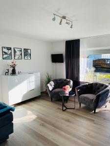 a living room with two chairs and a table at Zollernalb-Apartment MG in Albstadt