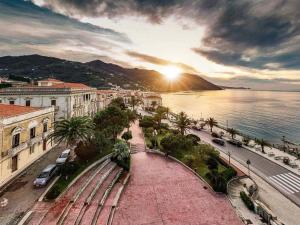 a view of a city with the sun setting over the water at Casa vacanza Gioiosa Sea in Gioiosa Marea