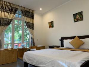 a bedroom with a bed and a large window at Khách sạn Hương Mê in Buon Ma Thuot