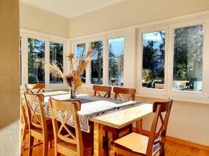 a dining room with a table and chairs and windows at Willa Burzynin in Karpacz