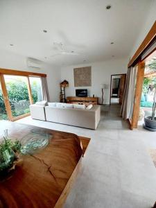 een woonkamer met een witte bank en een tafel bij Villa Emmylien in Dalung