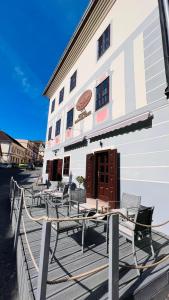 ein Gebäude mit Tischen und Stühlen auf einer Terrasse in der Unterkunft Hotel Salamander in Banská Štiavnica