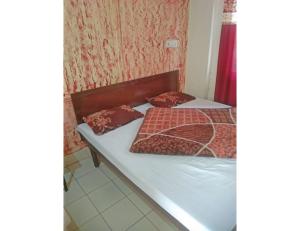 a bed with two pillows on it in a room at Hotel Landmark Lodge, Jammu in Jammu