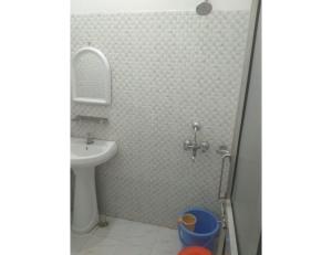 a bathroom with a shower with a sink and a toilet at Hotel Landmark Lodge, Jammu in Jammu