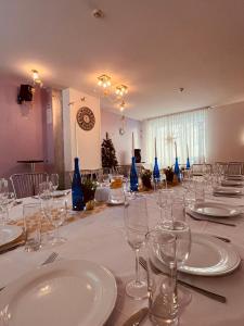 a long table with glasses and plates on it at Lilaste.eu in Lilaste