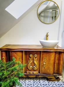 a wooden cabinet with a sink and a mirror at Dom na Podlasiu in Dziadkowice
