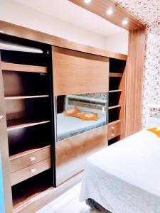 a bedroom with a bed and a large wooden closet at Casa aconchegante in Campo Grande
