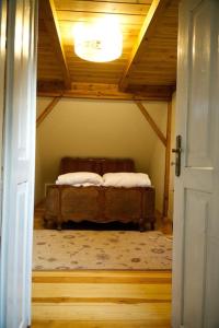 een slaapkamer met een bed in een kamer met een plafond bij Dom na Podlasiu in Dziadkowice