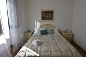 a bedroom with a bed with a blanket on it at La casa di Nonno in Iglesias