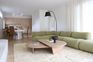 a living room with a green couch and a table at The Heads House in Shoalhaven Heads
