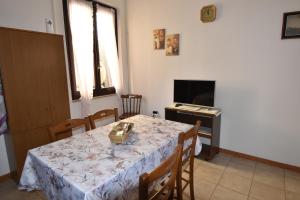 a dining room with a table and a television at La casa di Nonno in Iglesias