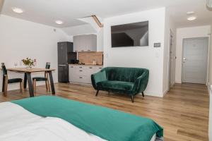 a bedroom with a green chair and a table at The Old Townhouse in Krosno