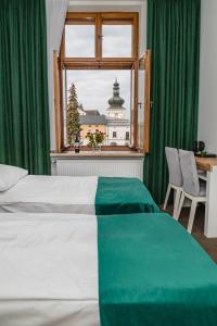 a bedroom with a bed and a window with green curtains at The Old Townhouse in Krosno