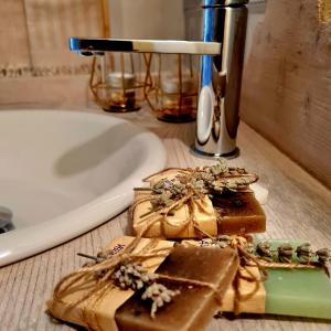 a bathroom sink with two pieces of chocolate on a counter at dalla fortezza al mare - la vostra casa a San Leo in San Leo