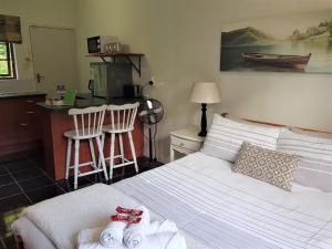 um quarto com uma cama e uma cozinha com cadeiras em Pine Cone Corner em George
