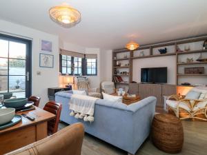 a living room with a blue couch and a table at 8 Oaks Court in Leiston
