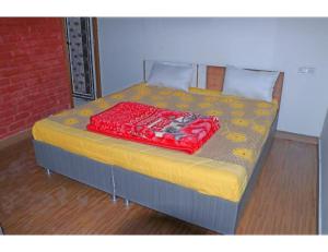 a bed with a red pillow on top of it at Hotel Jungle View Resort, Bhogpur in Kandogal