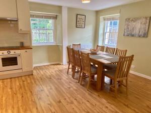 una cucina e una sala da pranzo con tavolo e sedie di Charming 3/4 bedroom semi-detached cottage. a Carberry