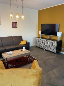 a living room with a couch and a tv at Apartament „Dwie Wieże” in Katowice