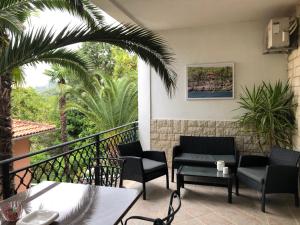 a patio with chairs and tables on a balcony at Apartment Nika in Lovran +14 photos