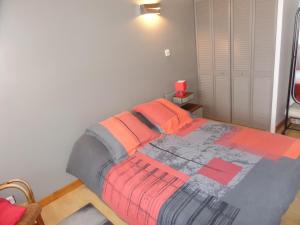 1 dormitorio con 1 cama con sábanas naranjas y grises en HAVRE DE PAIX à SALAISE SUR SANNE (38), en Salaise-sur-Sanne