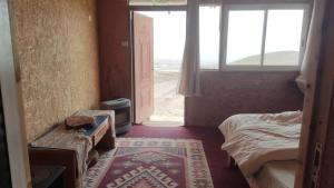 pokój z łóżkiem i oknem oraz łóżko o wymiarach 6 x 6 x 6 w obiekcie Zman Midbar Eco Spirit Lodge for Peace w mieście Arad