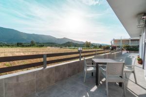 a patio with a table and chairs and a field at Central Apartments in Alikanas