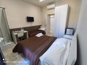 una camera con letto, scrivania e TV di Hotel Emmy a Milano