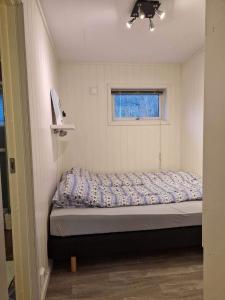 カベルヴォーグにあるApartment in Kabelvågの窓付きの小さな部屋の小さなベッド1台分です。