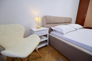 a small bedroom with a bed and a chair at FLH - Kaly's Place in Sibiu