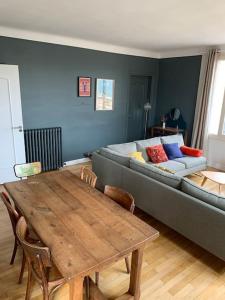 a living room with a couch and a wooden table at Appart 90m2 lumineux, centre, vue église penchée in Caen