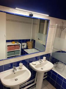 a bathroom with two sinks and a mirror and a tub at Appart 90m2 lumineux, centre, vue église penchée in Caen