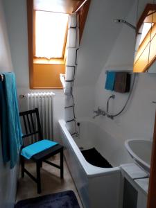 y baño con bañera, silla y lavamanos. en Ferienwohnung Sonnenblick, en Oberharmersbach