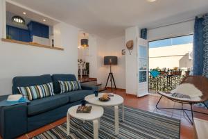 un soggiorno con divano blu e 2 tavoli di Beautiful Spanish apartment in Torremolinos a Torremolinos