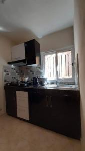 a kitchen with a black counter top and a window at VIllAPPART ( appartement au rc) in Antananarivo