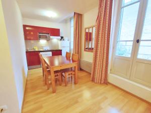 a kitchen and dining room with a table and a window at Val de Jade, Le Marmotton, T2, centre Luchon, wifi, casier à skis, 5 personnes in Luchon