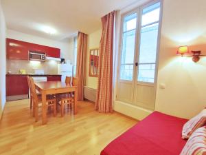 a living room with a table and a kitchen at Val de Jade, Le Marmotton, T2, centre Luchon, wifi, casier à skis, 5 personnes in Luchon