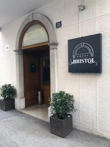 una puerta delantera de un edificio con dos macetas en Hotel Bristol, en Trieste