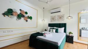 BluO Studio Noida - BathTub, Gym, Balcony, Garden في نويدا: غرفة نوم مع سرير وبعض الأطباق على الحائط