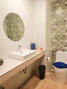 W łazience znajduje się umywalka, toaleta i lustro. w obiekcie M CASA HOTEL PATTAYA w mieście Nong Prue